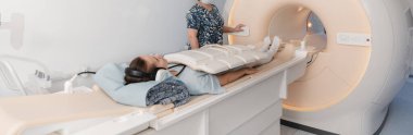 Tomografi tomografisi ya da hastanede MRI taraması olan doktor, hemşire ve hasta. Radyografi bölümünün içi. Beyaz odada teknolojik olarak gelişmiş ekipmanlar var. Manyetik rezonans tanılama makinesi