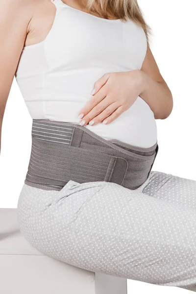 Brzuch ciężarnej kobiety w ciążowym pasie ciążowym izolowany na białym tle. Wsparcie talii, pleców, brzucha. Aparat na brzuch. Zespół brzucha na ciążę. Ortopedyczny pas podporowy brzucha — Zdjęcie stockowe