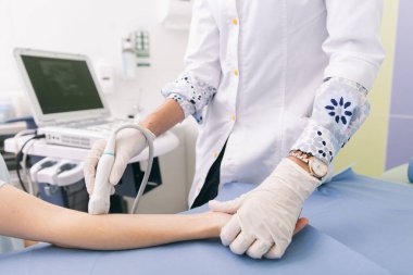Doktor eline ultrason yapıyor. Yakın plan. Doktor ultrason sonuçlarını hastaya gösterir. Tıbbi ultrason taraması. Kas gevşemesi için rehabilitasyon uygulaması enjeksiyonu