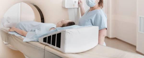 Tomografi tomografisi ya da hastanede MRI taraması olan doktor, hemşire ve hasta. Radyografi bölümünün içi. Beyaz odada teknolojik olarak gelişmiş ekipmanlar var. Manyetik rezonans tanılama makinesi