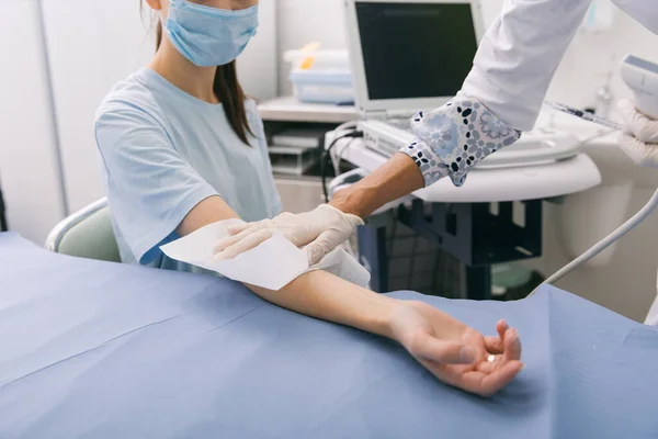 Doktor eline ultrason yapıyor. Yakın plan. Doktor ultrason sonuçlarını hastaya gösterir. Tıbbi ultrason taraması. Kas gevşemesi için botoks enjeksiyonunun rehabilitasyon uygulaması