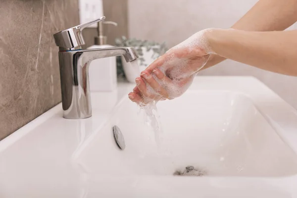 Миття рук під струменем води. Миття рук, що натираються милом для запобігання вірусу корона, гігієна, щоб зупинити поширення вірусу корона або громадського миття. Подробиці концепції гігієни — стокове фото