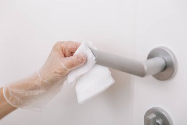 Islak mendil ve beyaz eldivenlerle kapı kolları. Ev kapısı bağlantısını temizlemek için havlu kullanan kadın eli. Hastane ve halka açık alanlarda korona virüsüne karşı yüzeylerin sterilize edilmesi