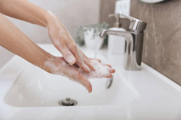 Мыть руки под проточной водопроводной краном. Мытье рук с мылом для предотвращения коронного вируса, гигиены, чтобы остановить распространение коронного вируса в или общественную уборную. Концепция гигиены рук — стоковое фото
