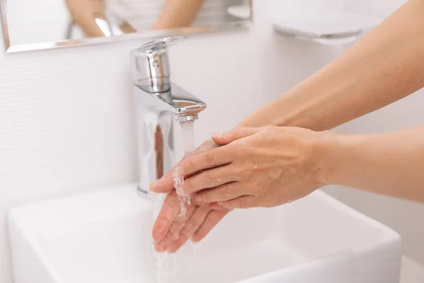 Hände waschen unter dem fließenden Wasserhahn. Händewaschen mit Seife zur Vorbeugung des Coronavirus, Hygiene gegen die Ausbreitung des Coronavirus in öffentlichen Waschräumen. Hygienekonzept Hand in Hand — Stockfoto