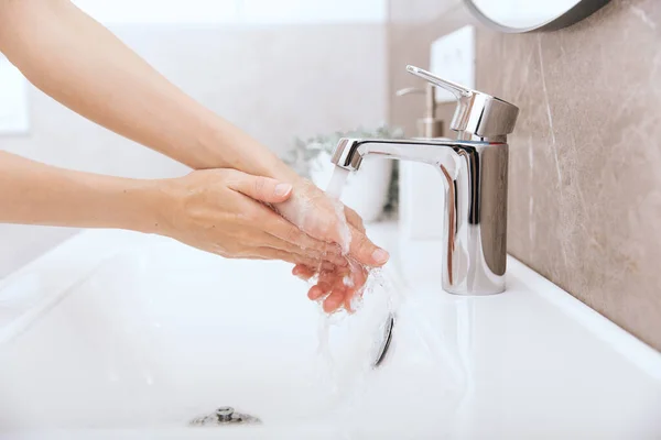 Mycie rąk pod cieknącym kranem. Mycie rąk mydłem w celu zapobiegania wirusom korony, higieny, aby zatrzymać rozprzestrzenianie się wirusa korony w lub publicznej myjni. Koncepcja higieny szczegółowy opis strony — Zdjęcie stockowe