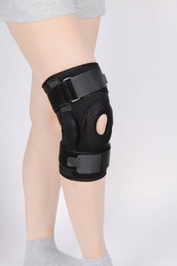 Diz Destek Kolu beyaz arka planda izole edilmiş bir bacak üzerinde. Elastik ortopedik ortopedi. Diz saplantısı, yaralanma ve ağrı için anatomik destek. Koruyucu diz eklemi bandaj kolu. Travma, rehabilitasyon.