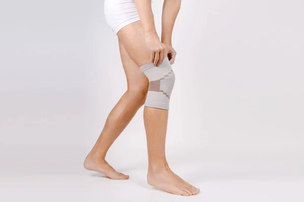 Knee Support Brace na nodze odizolowany na białym tle. Elastyczna ortopeda ortopedyczna. Anatomiczne aparaty na kolana, urazy i ból. Ochronna opaska na staw kolanowy. Uraz, rehabilitacja — Zdjęcie stockowe