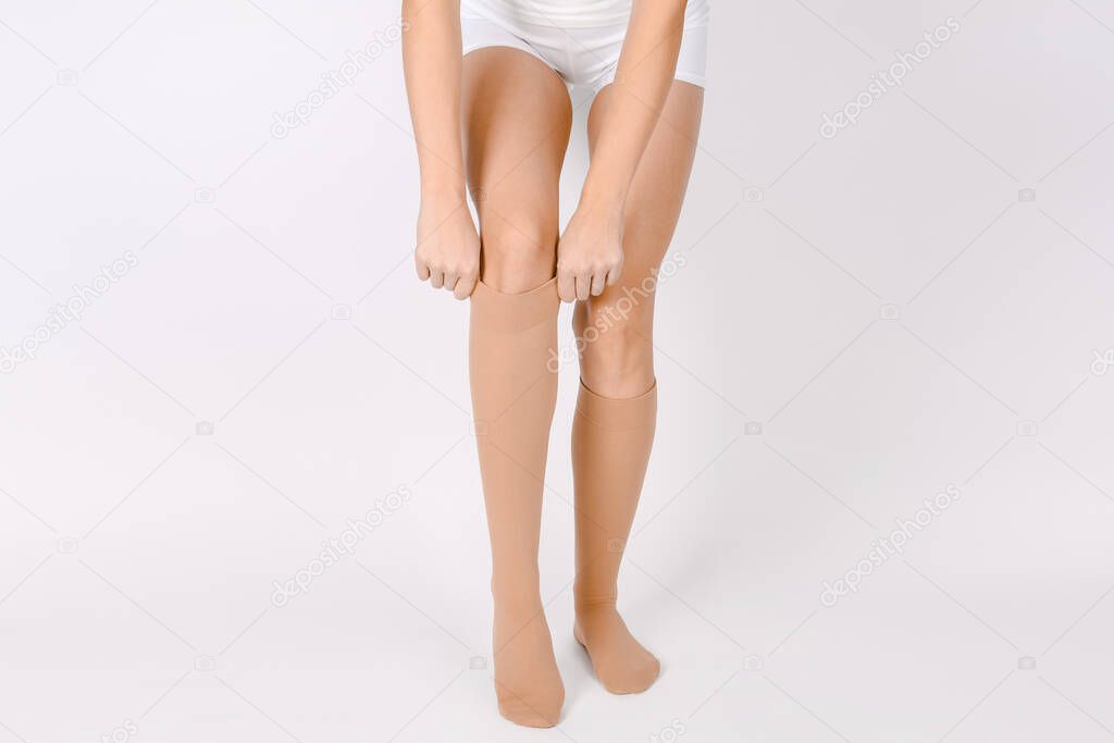 Medical Compression Stockings for varicose veins and venouse therapy. Compression Hosiery. Sock for sports isolated on white background. Beige color socks mock up for advertising, branding, design