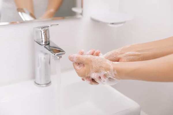 Hände waschen unter dem fließenden Wasserhahn. Händewaschen mit Seife zur Vorbeugung des Coronavirus, Hygiene gegen die Ausbreitung des Coronavirus in öffentlichen Waschräumen. Hygienekonzept Hand in Hand — Stockfoto