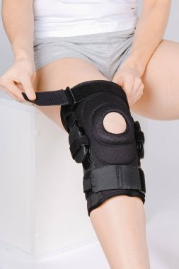 Diz Destek Kolu beyaz arka planda izole edilmiş bir bacak üzerinde. Elastik ortopedik ortopedi. Diz saplantısı, yaralanma ve ağrı için anatomik destek. Koruyucu diz eklemi bandaj kolu. Travma, rehabilitasyon.