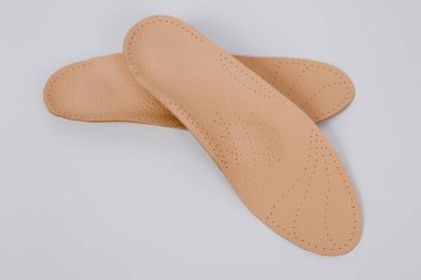 Beyaz arka planda izole edilmiş ortopedik tabanlar. Tıbbi tabanlar. Ayak bakımı. Kesik tabanlı katmanlar. Düz taban ve ayak hastalıklarının tedavisi ve önlenmesi. Ayakkabının iç tabanları
