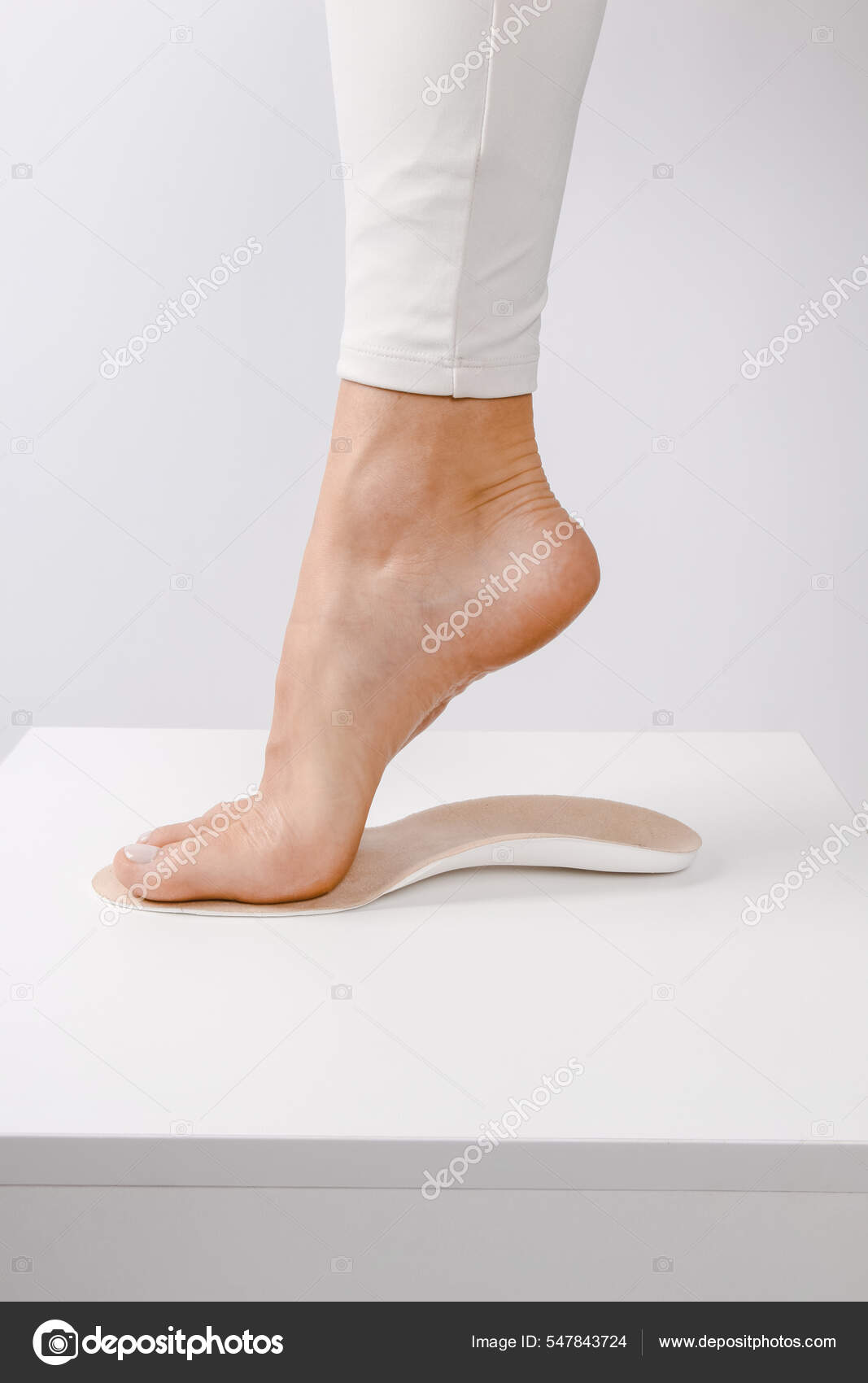 Medical insoles. Isolated orthopedic insoles on a white background.  Treatment and prevention of flat feet and foot diseases. Foot care. Insole  cutaway layers. Leg hanging over the insole Stock Photo by ©ml_photo