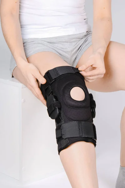 Diz Destek Kolu beyaz arka planda izole edilmiş bir bacak üzerinde. Elastik ortopedik ortopedi. Diz saplantısı, yaralanma ve ağrı için anatomik destek. Koruyucu diz eklemi bandaj kolu. Travma, rehabilitasyon.
