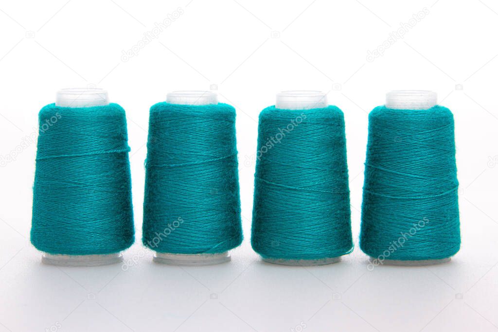 Green spool of thread isolated on white background. Skein of woolen threads. Yarn for knitting. Materials for sewing machine. Coil