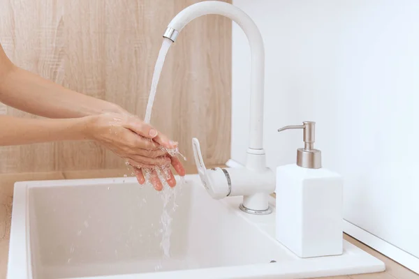 Mencuci tangan di bawah keran air yang mengalir. Mencuci tangan digosok dengan sabun untuk pencegahan virus korona, kebersihan untuk menghentikan penyebaran virus korona di atau ruang cuci umum. Detail tangan konsep kebersihan — Stok Foto