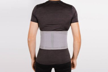 Beyaz arka planda izole edilmiş insan vücudunda bel desteği. Sırt travması. Sırt desteği, ortopedik bel, sırt kasları için destek kemeri. Sırt sorunları