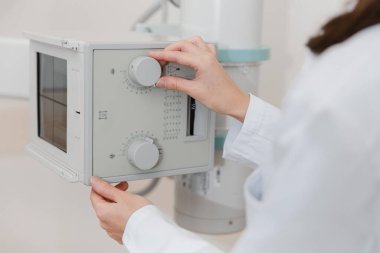 Hastane Radyoloji Odası. Florografi için röntgen makinesi. Doktor radyoloji uzmanı röntgen cihazını radyografi için ayarlıyor. Tıbbi ekipman. Klinikte göğüs, kalp ya da akciğerler taranıyor