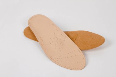 Beyaz arka planda izole edilmiş tabanlar. Tıbbi ortopedik tabanlar. Ayak bakımı. Kesik tabanlı katmanlar. Düz taban ve ayak hastalıklarının tedavisi ve önlenmesi. Ayakkabının iç tabanları