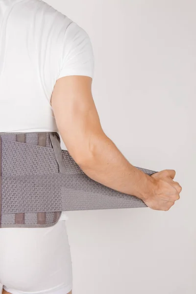 Lumbar brace on the human body isolated on a white background. Trauma of back. Back brace, orthopedic lumbar, support belt for back muscles. Lower back problems health