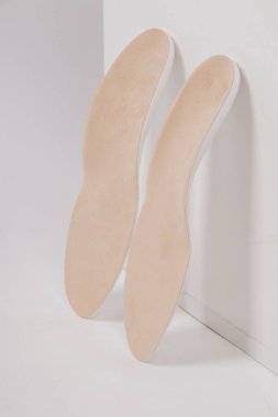 Beyaz arka planda izole edilmiş tabanlar. Tıbbi ortopedik tabanlar. Ayak bakımı. Kesik tabanlı katmanlar. Düz taban ve ayak hastalıklarının tedavisi ve önlenmesi. Ayakkabının iç tabanları