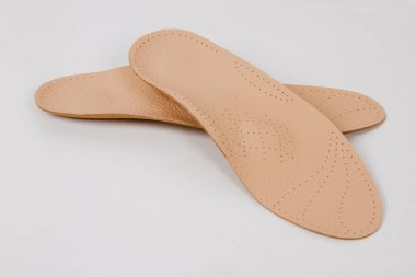 Beyaz arka planda izole edilmiş tabanlar. Tıbbi ortopedik tabanlar. Ayak bakımı. Kesik tabanlı katmanlar. Düz taban ve ayak hastalıklarının tedavisi ve önlenmesi. Ayakkabının iç tabanları