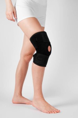 Diz Destek Kolu beyaz arka planda izole edilmiş bir bacak üzerinde. Elastik ortopedik ortopedi. Diz saplantısı, yaralanma ve ağrı için anatomik destek. Koruyucu diz eklemi bandaj kolu. Travma, rehabilitasyon..