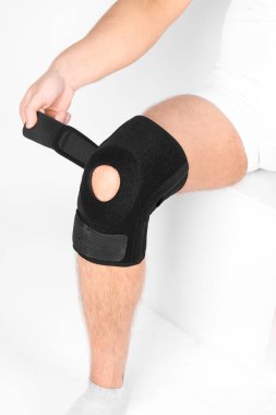 Diz Destek Kolu beyaz arka planda izole edilmiş bir bacak üzerinde. Elastik ortopedik ortopedi. Diz saplantısı, yaralanma ve ağrı için anatomik destek. Koruyucu diz eklemi bandaj kolu. Travma, rehabilitasyon..