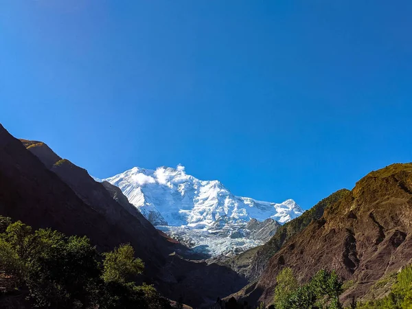 ギルギット バルティスタン パキスタンに位置するラカポシ峰と呼ばれる2つの巨大な山々の間に見える雪の山のピーク — ストック写真