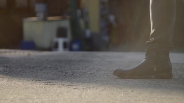 日没時に歩いている男の黒いブーツの上を閉じて — ストック動画