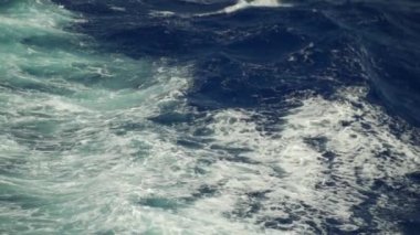 Ağır çekimde büyük bir geminin arka koltuğundaki denize bakıyorum.