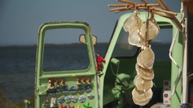 Sicilya sahillerinde hediyelik eşya standı ve rüzgarda asılı duran deniz kabuğu.