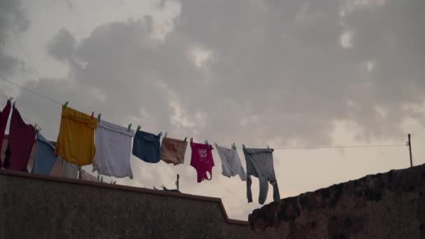 Güneşin Batışında Rüzgarda Sallanan Bir Evin Çatısındaki Renkli Giysiler — Stok video