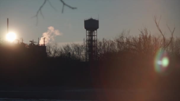 日落时靠近森林和中心水塔的一家化工厂 — 图库视频影像