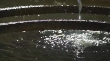 Bir dağ kaynağından yavaş çekimde düşen suyun bir kısmını kapat