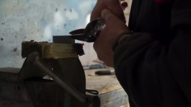 Metal bir plakayı makasla kesen bir tamirci.