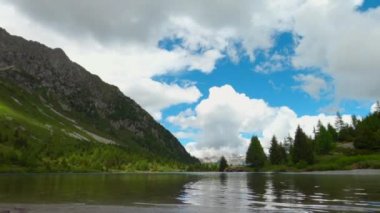 Yazın bulutlu bir gününde bir dağ gölünün zaman atlaması.