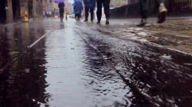 Yağmurlu bir günde Edinburgh 'da yürüyen bazı insanlar, yerden manzara