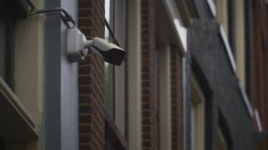 Eski bir tuğla duvardaki güvenlik kamerası.