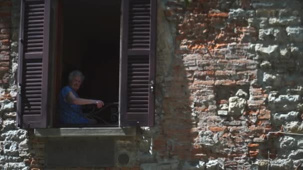 Uma Velha Italiana Sentada Uma Janela Olhando Para Fora Dia — Vídeo de Stock
