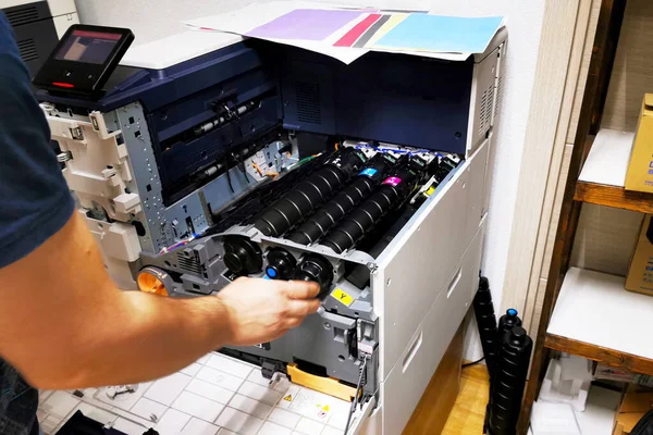 A man replaces toner in a laser printer. toner cartridge for printer printing laser stationery office equipment repair concept, digital copier