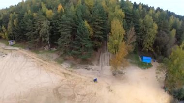 Taş ocağında uçan beyaz kum ormanı sarı ağaçlar sonbahar güzel su gölü mavi gökyüzü