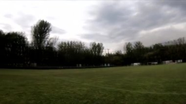 İnsanların yeşil çimlerde futbol oynadığı stadyumda uçarak.