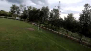 İnsanların yeşil çimlerde futbol oynadığı stadyumda uçarak.