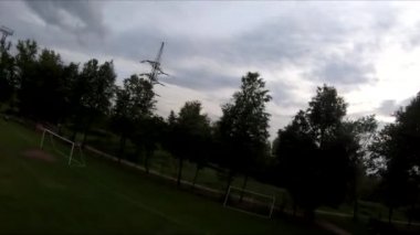 İnsanların yeşil çimlerde futbol oynadığı stadyumda uçarak.