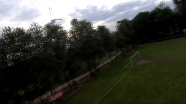 İnsanların yeşil çimlerde futbol oynadığı stadyumda uçarak.