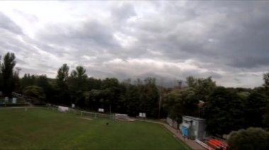 İnsanların yeşil çimlerde futbol oynadığı stadyumda uçarak.