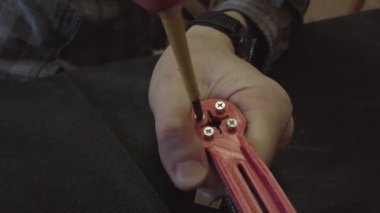 Parçalanmış FPV kuadrokopteri, siyah bir masanın üzerine kendin yap drone onarımı, eski plastik bir çerçevenin çıkarılması, kırık parçalar, İngiliz anahtarı ve tornavida ile sökülmesi, elektronik, mikro devreler, tamir, lehimleme.