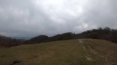 fpv Quadcopter uçuşu dağlarda, Sochi, çimen bir açıklıkta, gri yeşil orman, güzel yüksek kayalar, büyük taşlar, mavi gökyüzü ve deniz ufukta