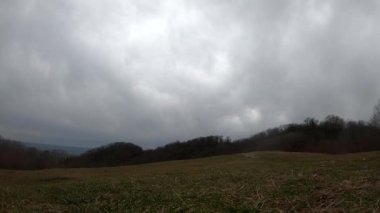 fpv Quadcopter uçuşu dağlarda, Sochi, çimen bir açıklıkta, gri yeşil orman, güzel yüksek kayalar, büyük taşlar, mavi gökyüzü ve deniz ufukta